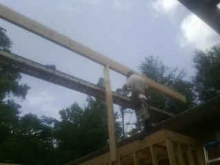 Carpenter setting a ridge beam over a new addition frame — Ice Dam Removal by Roofing Brothers in Marlborough